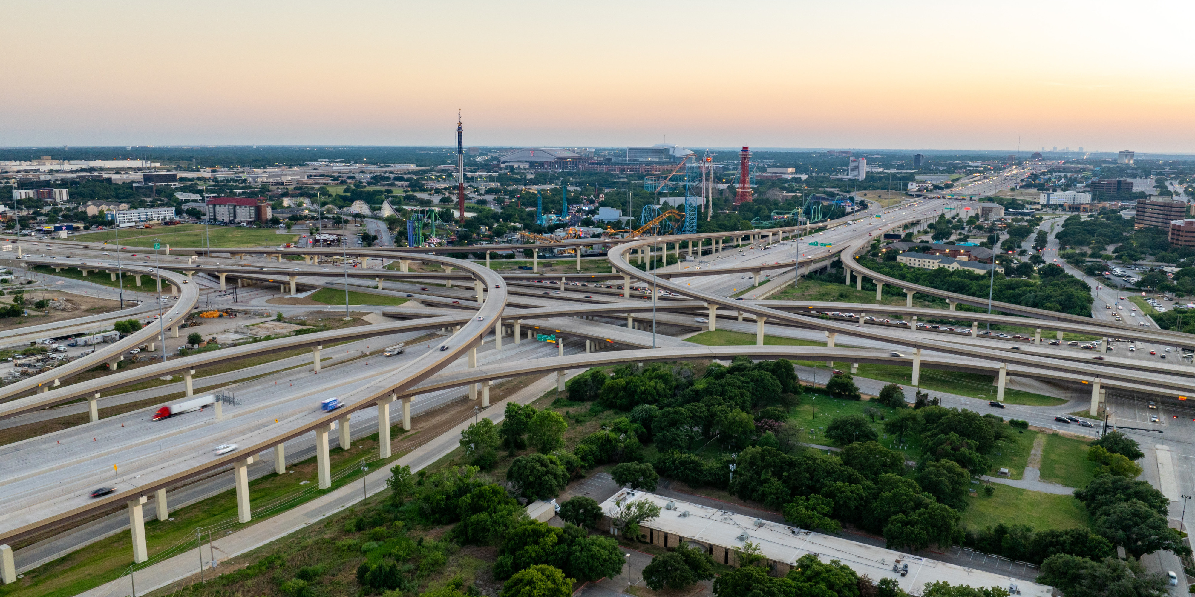 Aerial view of criss-crossing interstate bridges with Six Flags and stadiums in background