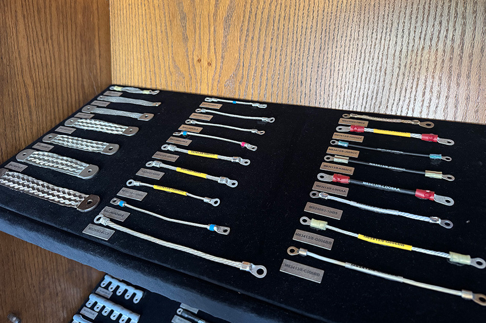 Black tray showcasing different sizes and strengths of bonding jumper cables.