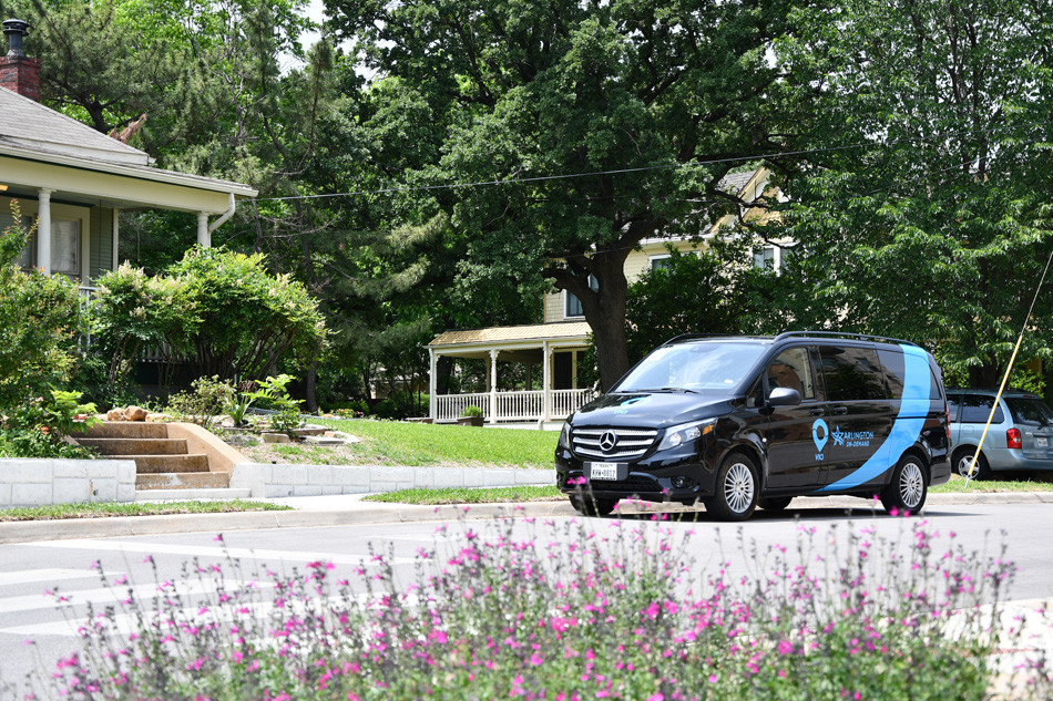 Via Rideshare van on street with flowers in the foreground